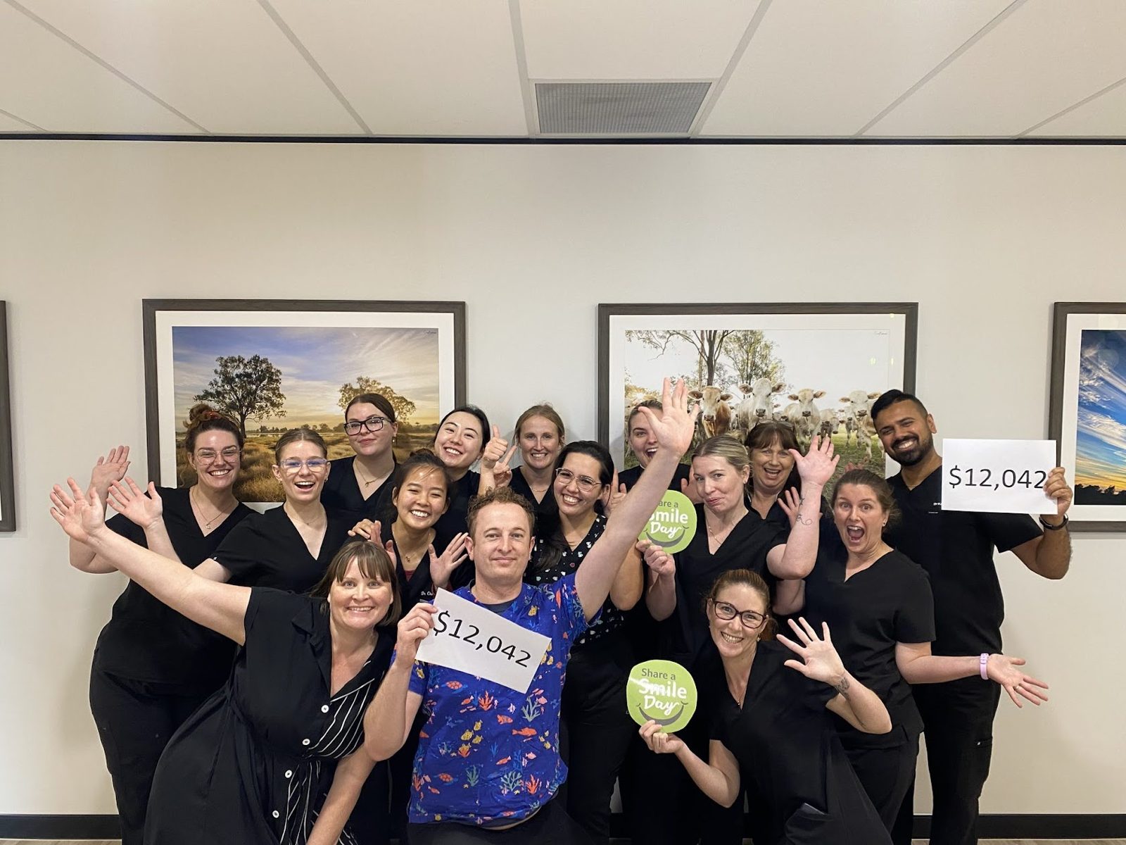 Team holding the charity day fundraising total